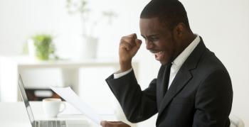 An African-American man opening up an acceptance letter for a job, and is celebrating.