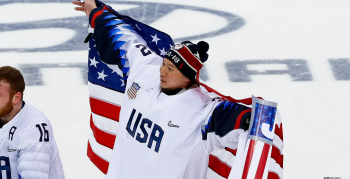 An image of Paralympian, Jen Lee holding American Flags on the Ice.