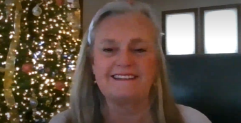 Photo of Tamie Hooper a white woman with long gray hair and a big smile. 