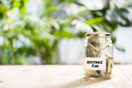 Jar of money that says Assistance Fund