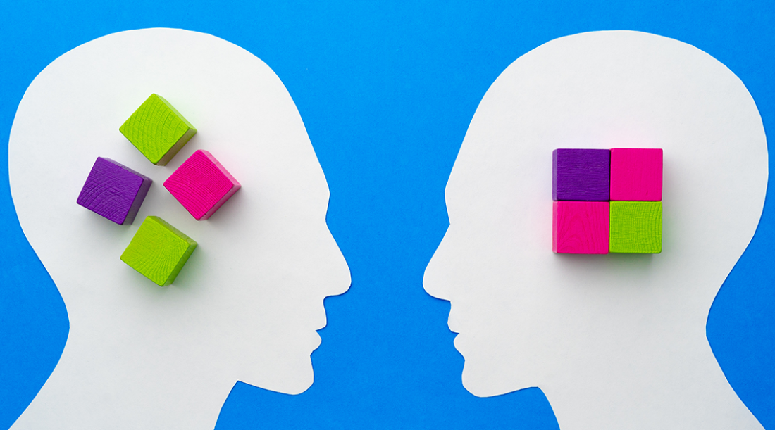 Blue background with white silhouettes of heads that have green, purple, and pink blocks in the center.
